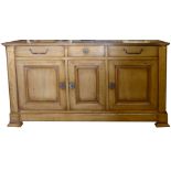 A FRENCH DESIGN BLONDE OAK DRESSER With three drawers above three cupboards, fitted with heavy brass