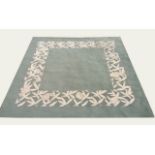 A CONTEMPORARY WOOLLEN RUG The green ground contained in a woven floral border 230 x 230 cm