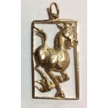 AN UNUSUAL 9CT GOLD PENDANT Having a stylized comical horse, held in a pierced rectangular frame. (