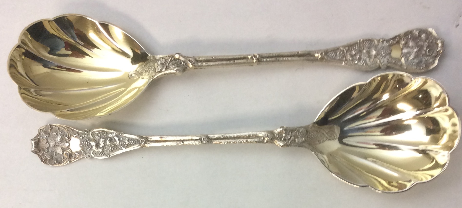 A PAIR OF VICTORIAN SILVER BERRY SPOONS The handles embossed with vines and leaves and having a gilt - Image 2 of 2