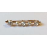 A VINTAGE 14CT GOLD, DIAMOND AND PEARL BROOCH The three graduating round cut diamonds interspersed