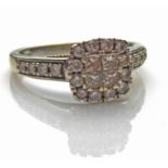 A WHITE METAL AND DIAMOND RING Set with a total of twenty round cut and four cushion cut diamonds,