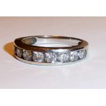 A WHITE METAL AND DIAMOND HALF HOOP RING Having nine brilliant cut diamonds channel set into the