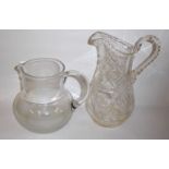 TWO LARGE 20TH CENTURY GLASS WATER JUGS One having cut decoration featuring stars and hatches. (