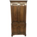 A GEORGE III MAHOGANY FLOOR STANDING CORNER CUPBOARD The panelled doors opening to reveal shelves,