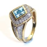 A 9CT GOLD, DIAMOND AND AQUAMARINE RING The lozenge shaped facet having four cushion cut