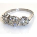 AN 18CT WHITE GOLD AND DIAMOND THREE STONE RING With three graduated round cut diamonds (size T). (