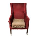 A GEORGIAN III PERIOD WING ARMCHAIR In upholstery, raised on square tapering legs terminating on