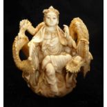 A 19TH CENTURY IVORY NETSUKE Depicting a deity with dragon coiled around her. (h 5.5cm)