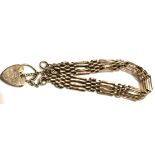 A VICTORIAN 9CT GOLD GATE BRACELET The four bar link leading to a heart form locket clasp. (approx
