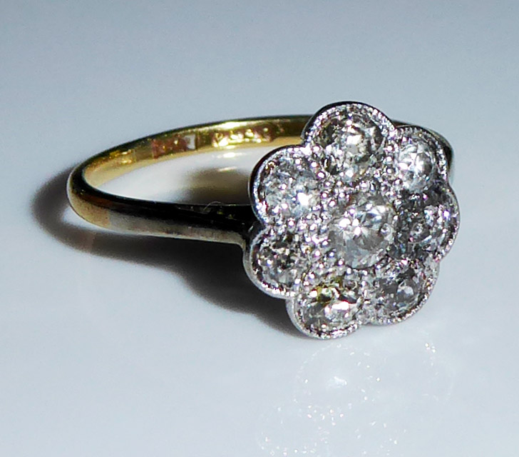 AN ANTIQUE 18CT GOLD AND PLATINUM SET DAISY CLUSTER RING