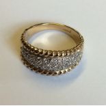 A 9CT GOLD AND DIAMOND CLUSTER RING Having pavé diamonds set in a lozenge edged by a rope twist
