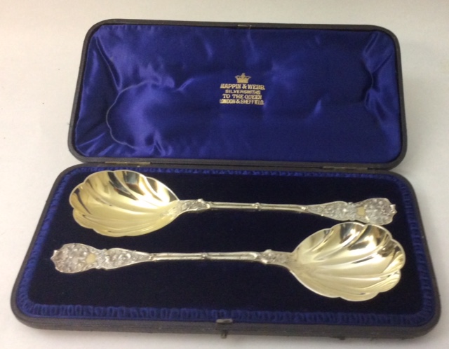 A PAIR OF VICTORIAN SILVER BERRY SPOONS The handles embossed with vines and leaves and having a gilt