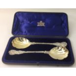A PAIR OF VICTORIAN SILVER BERRY SPOONS The handles embossed with vines and leaves and having a gilt