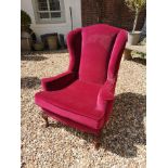 A GEORGIAN STYLE WING ARMCHAIR Upholstered in a red wine velvet, raised on cabriole legs with