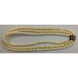 A VINTAGE THREE STRAND PEARL NECKLACE Having single rows of uniform pearls leading to a silver