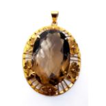 A VINTAGE 14CT GOLD AND SMOKY QUARTZ PENDANT Set with an oval cut stone held in a pierced floral