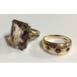A VINTAGE YELLOW METAL AND SMOKY QUARTZ RING Having a baguette cut faceted stone held in a pierced