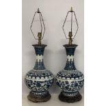 A PAIR OF CHINESE MING DESIGN TABLE LAMPS With blue and white decoration on hardwood stands. (73cm)