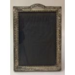 AN EARLY 20TH CENTURY SILVER PHOTO FRAME Embossed with a geometric floral style border and easel