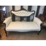AN EDWARDIAN MAHOGANY TWO SEATER SETTEE With button back upholstery, raised on cabriole legs.