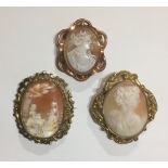 THREE YELLOW METAL CAMEO BROOCHES To include female portrait examples and a romantic courtyard