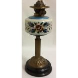 AN EDWARDIAN BRASS AND COLOURED GLASS OIL LAMP The spherical well hand painted with floral