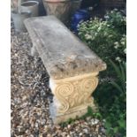 A RECONSTITUTED STONE GARDEN SEAT Of classical design. (120cm x 38cm x 44cm)