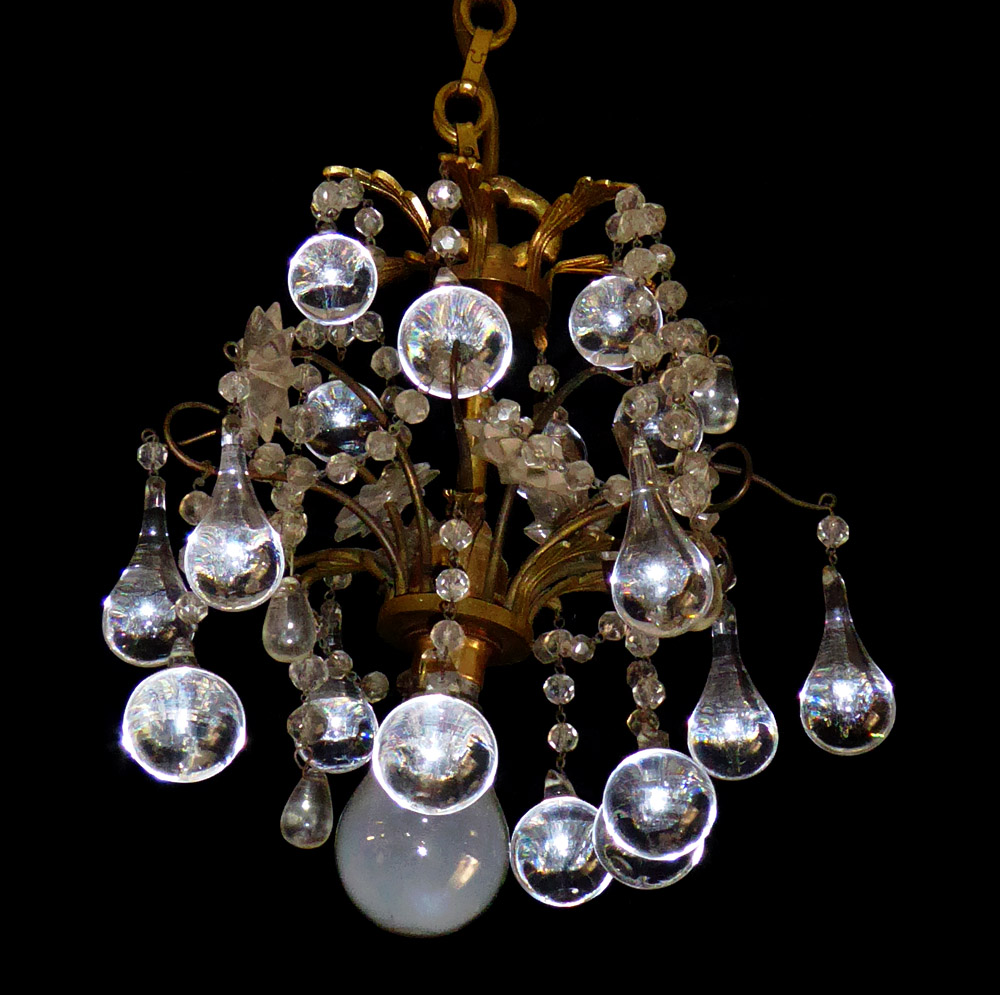 A PAIR OF EARLY 20TH CENTURY GILT BRONZE CHANDELIERS Hung with crystal prism drops. (55cm)