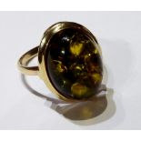 A VINTAGE 9CT GOLD AND AMBER RING Having a cabochon cut stone and held in a plain gold shank.