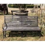 A MID 20TH CENTURY TEAK AND WROUGHT IRON GARDEN BENCH With scroll arms and raised on three scroll