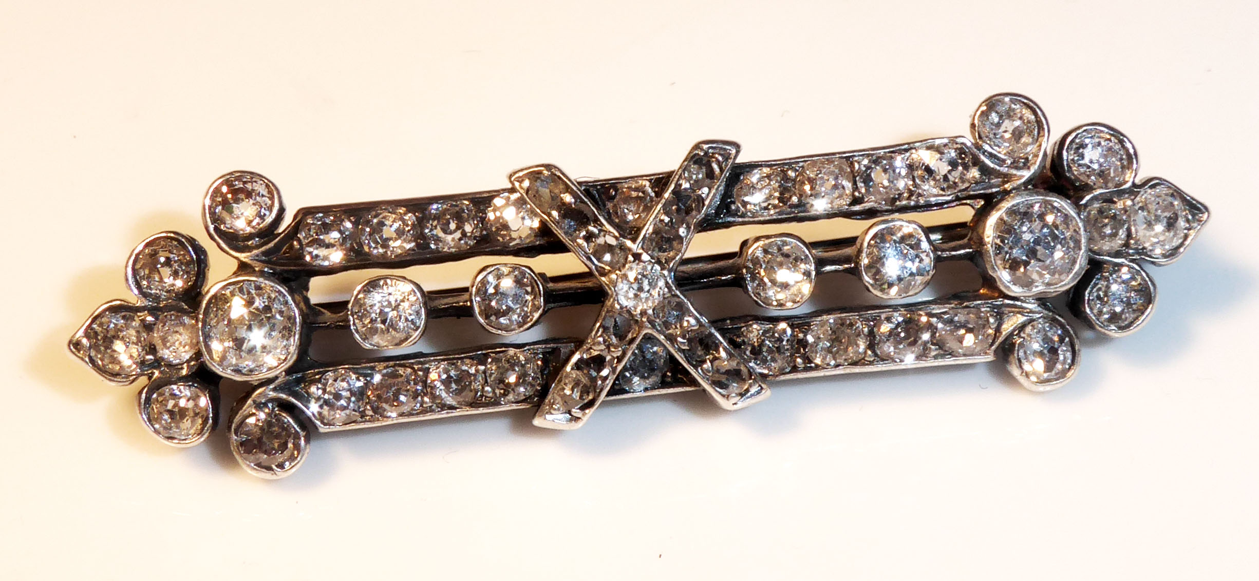 A YELLOW AND WHITE METAL DIAMOND BAR BROOCH Set with approximately 49 round cut diamonds.