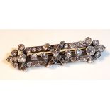 A YELLOW AND WHITE METAL DIAMOND BAR BROOCH Set with approximately 49 round cut diamonds.