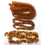 A COLLECTION OF THREE VINTAGE AMBER NECKLACES To include a necklace constructed of disc segments,