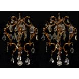 A PAIR OF EARLY 20TH CENTURY GILT BRONZE CHANDELIERS Hung with crystal prism drops. (55cm)