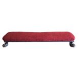 A VICTORIAN DUET FOOT STOOL The overstuffed seat upholstered in red velvet, on heavy mahogany lion