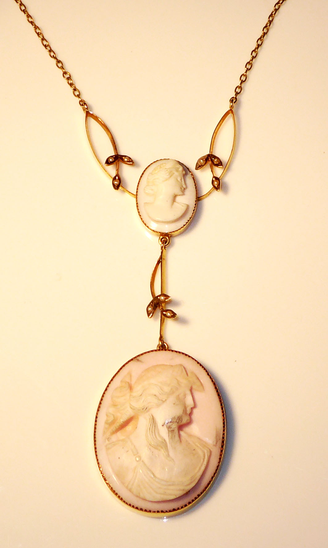 A 9CT GOLD CAMEO PENDANT With two cameos suspended from a fine 9ct gold chain.