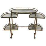 A STYLISH BRASS DRINKS TROLLEY The galleried top above two swing action tiers, with inset glass