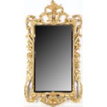 A CHIPPENDALE REVIVAL CARVED GILTWOOD WALL MIRROR The frame decorated with elaborate scrolling