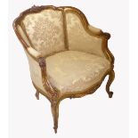 A 19TH CENTURY FRENCH ARMCHAIR The carved gilt wood frame centred with a cartouche in floral