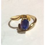 A VINTAGE YELLOW METAL AND SAPPHIRE SOLITAIRE RING Having a single oval cut stone set in a twist