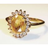 A 14CT GOLD, YELLOW SAPPHIRE AND DIAMOND RING With faceted oval cut sapphire flanked by eighteen