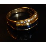 AN 18CT GOLD, SAPPHIRE AND DIAMOND RING Having a single row of square cut sapphires, flanked by