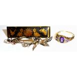 AN EDWARDIAN 9CT GOLD AND SEED PEARL BAR BROOCH Bird in flight with a bouquet of flowers, together