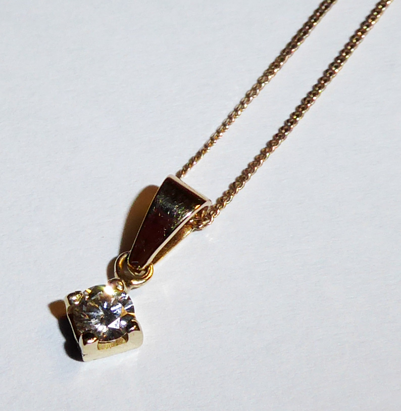 A 9CT GOLD AND DIAMOND PENDANT NECKLACE Having a single round cut diamond held in a square mount,