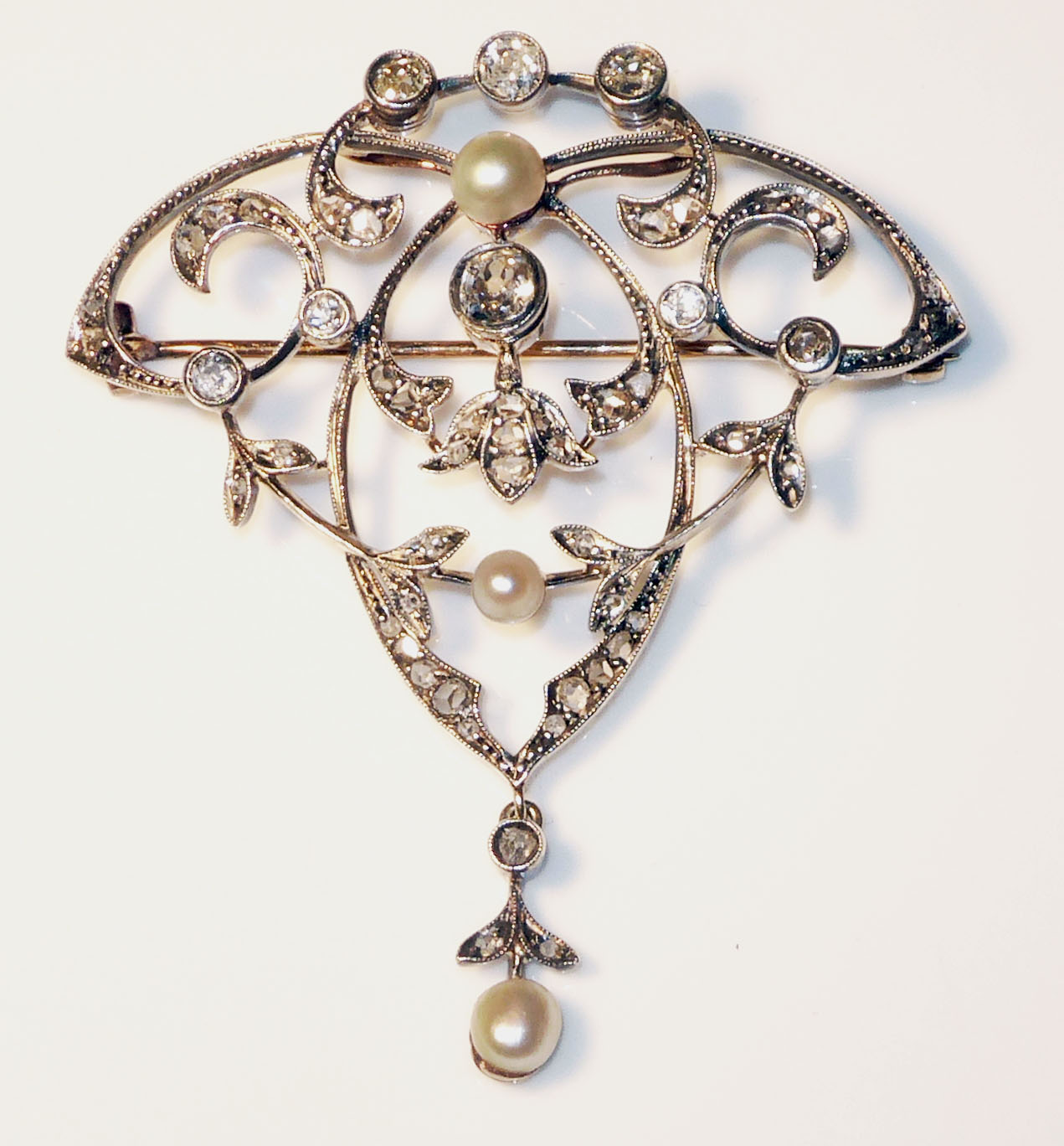 AN ANTIQUE YELLOW METAL, DIAMOND AND PEARL BROOCH Set with three pearls and approximately 45 round