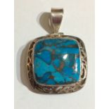 A VINTAGE SILVER AND TURQUOISE PENDANT Having a square cut stone, held in a pierced a mount. (approx