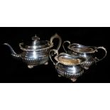 A VINTAGE SILVER THREE PIECE BACHELOR'S TEA SERVICE Having a gadrooned border and flutes to the
