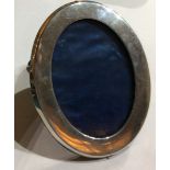 WILLIAM COMYNS, A 20TH CENTURY OVAL SILVER PHOTOGRAPH FRAME Plain form with easel back, hallmarked