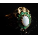 A VINTAGE 9CT GOLD, OPAL AND EMERALD CLUSTER RING Having a cabochon cut opal surrounded by a row